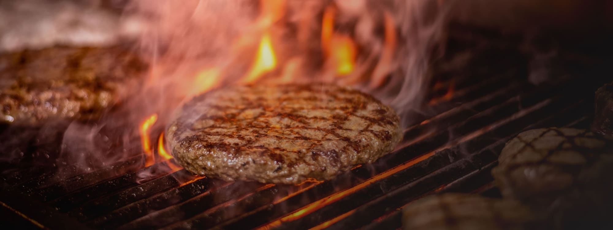 Beef burgers cooking on the grill